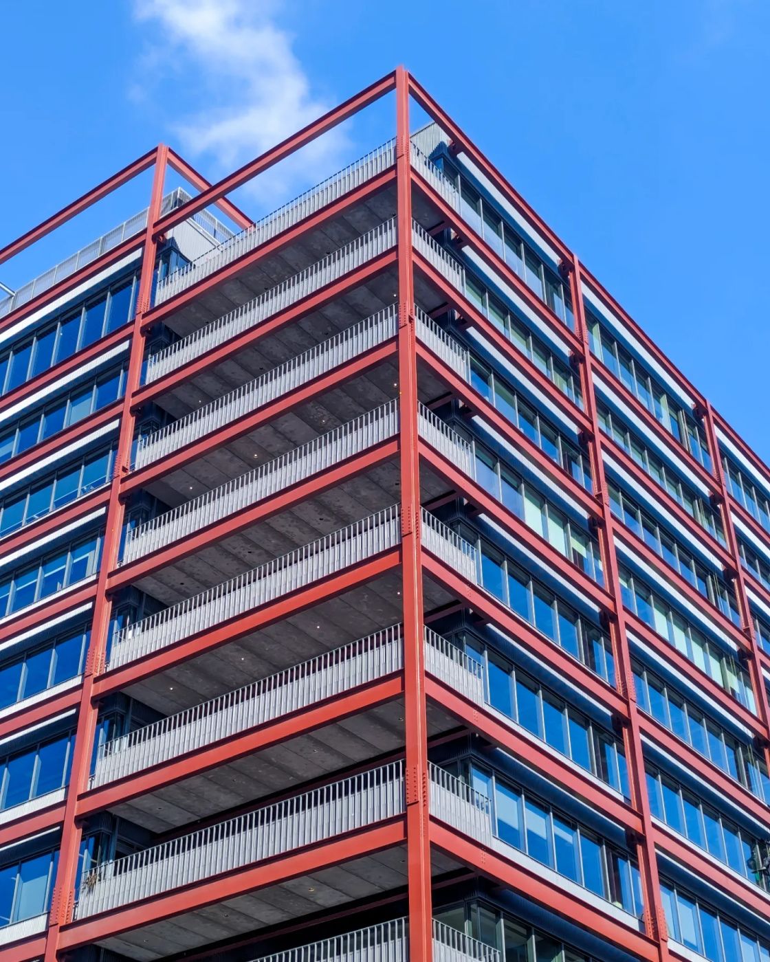 An office building wrapped in a bold red steel exoskeleton frame