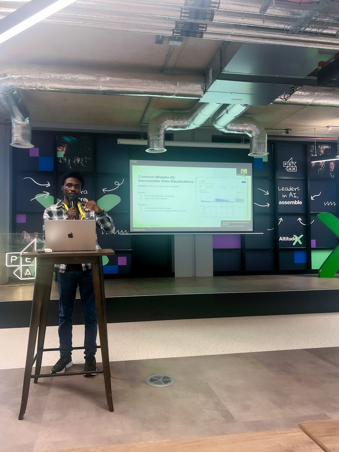 Me presenting on stage at a Peak AI event, my slide reading Common Mistake #3: Inaccessible Data Visualizations
